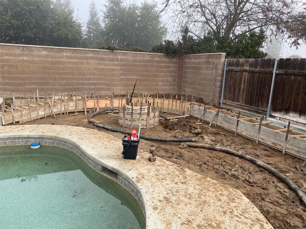 concrete set up for custom seat wall/planters and fire pit